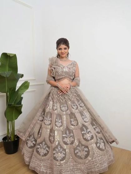 This elegant beige lehenga with silver embroidery is a sophisticated choice for any wedding function.