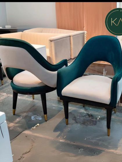 A pair of our green velvet and white accent chairs, showcasing their elegant, open-back design. These chairs are perfect for adding a touch of glamour and sophisticated seating to a living room or lounge area.