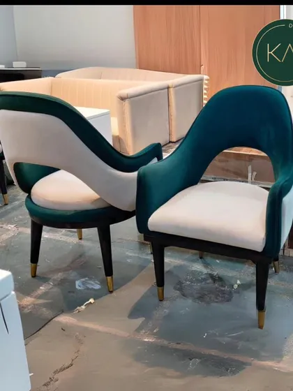 A pair of our green velvet and white accent chairs, showcasing their elegant, open-back design. These chairs are perfect for adding a touch of glamour and sophisticated seating to a living room or lounge area.