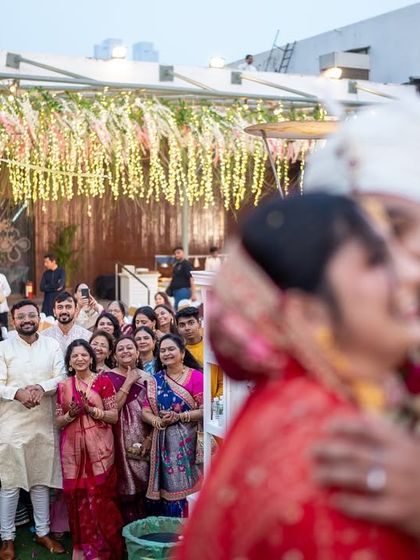 A blurry, artistic shot of the couple kissing, with the guests watching in the background. This photo captures the feeling of being in a bubble of love.