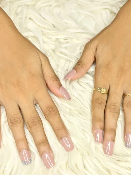 A chic and understated design featuring a sheer nude polish on square extensions with a silver glitter accent nail.