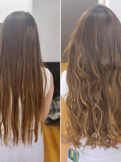 This client's long hair was enhanced with extensions to add more volume and texture. The final look, styled in soft waves, appears much fuller and healthier.