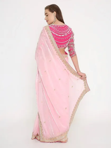 The back of this blouse is made for divas! The stunning pearl detailing on this magenta blouse adds a modern and glamorous touch to the soft pink saree.