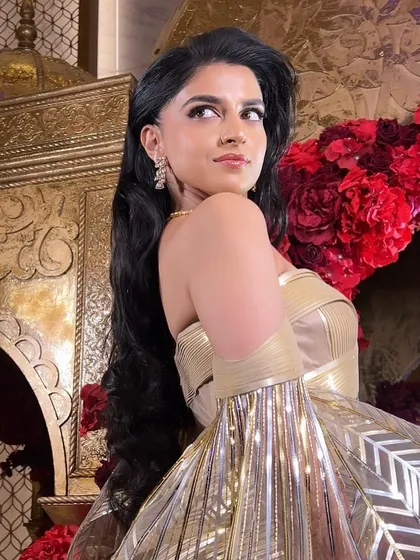 A side profile of the Sangeet look, showing the voluminous waves and how they create a powerful and glamorous silhouette.