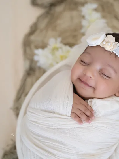 That sleepy newborn smile is one of the most precious things in the world. In this minimalist newborn portrait, I used soft, natural-looking light and a simple white swaddle to focus entirely on her serene expression. These are the fleeting moments I love to freeze in time.