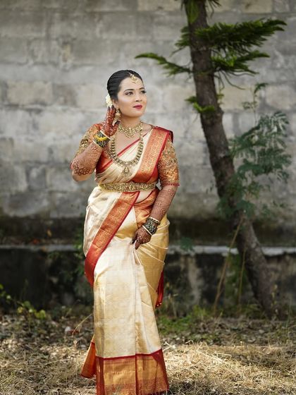 A full-length portrait of bride Samyak, showing how the makeup, hair, and saree draping come together for a complete and cohesive muhurtham look.