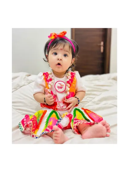 A modern take on festive wear. This little girl is wearing our colorful dhoti-style pants with a simple top and a bandhani print vest, a comfortable yet stylish choice for any festival.