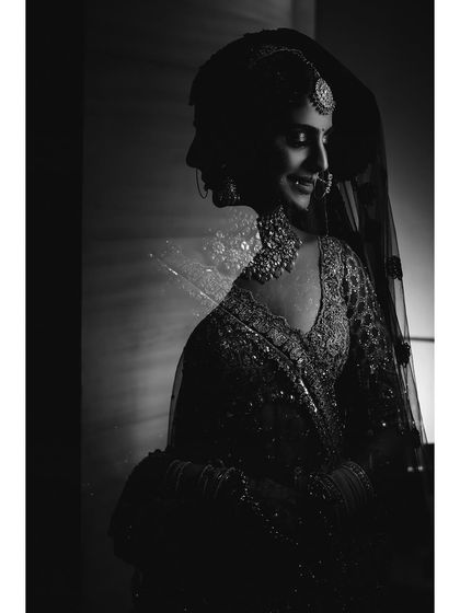 A striking black and white double exposure portrait of Vasudha. This artistic technique creates a layered, ethereal image that is both modern and timeless.