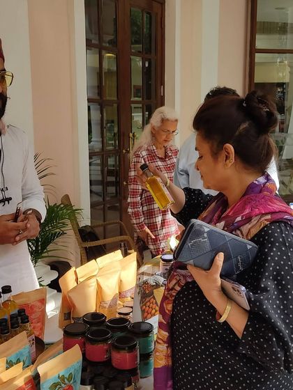 A customer inspecting a bottle of oil while talking to the producer.
