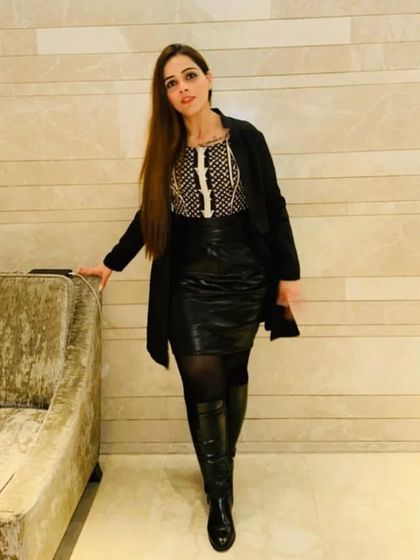 A powerful look featuring a leather skirt, thigh-high boots, and a printed top. This outfit is all about showcasing confidence and a strong sense of personal style.