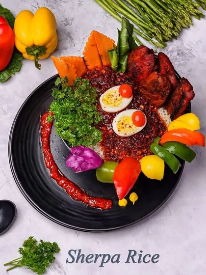 Our Sherpa Rice is a colourful and hearty meal. It's a bowl of rice topped with a rich gravy, boiled eggs, and fresh vegetables, making for a wholesome dish.