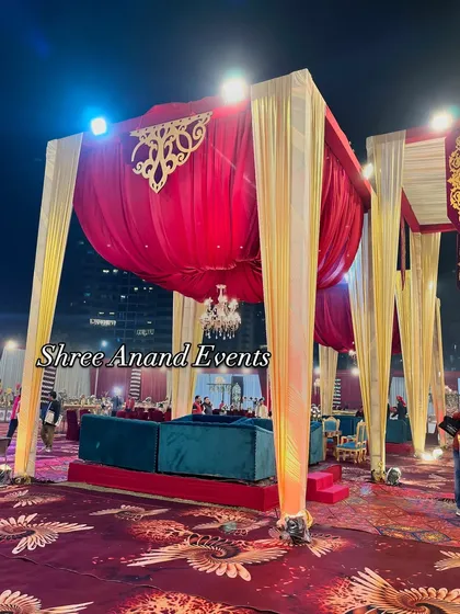 A majestic mandap structure with red and gold draping, creating a royal and traditional space for the wedding ceremony.