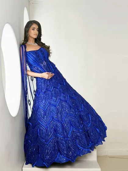 A bold, electric blue bridal lehenga with intricate embellishments and a flowing dupatta, designed for the bride who dares to stand out.