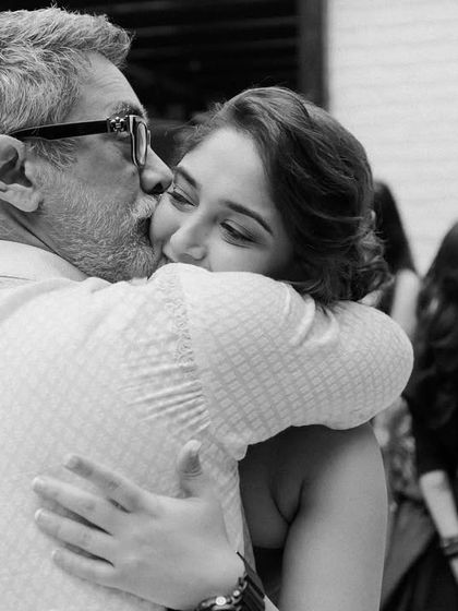 A father's affectionate kiss for his daughter. These are the quiet, tender moments that often happen away from the main ceremony, and they are just as important to the story of the day.