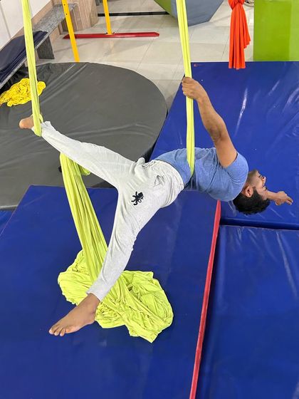 An adult student practices an inverted backbend, a challenging pose that builds significant core and back strength.