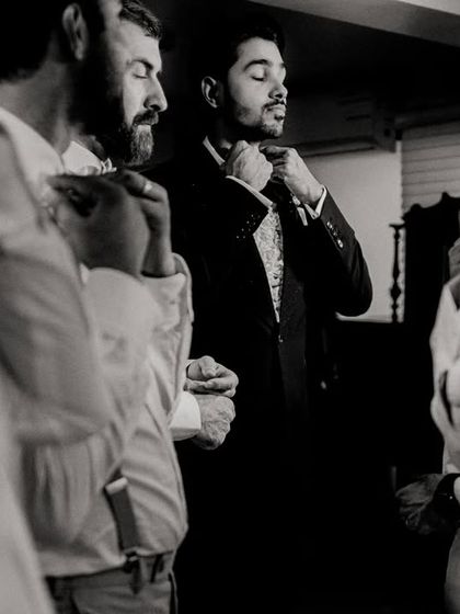 The groom and his groomsmen getting ready together. A candid, black and white shot that captures the anticipation.