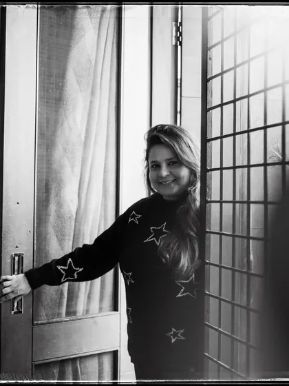 Anandita, framed by her doorway. Her warm smile makes this black and white portrait feel incredibly welcoming and bright.