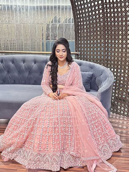 A different pose showing the full effect of the pink lehenga and the detailed hairstyle.