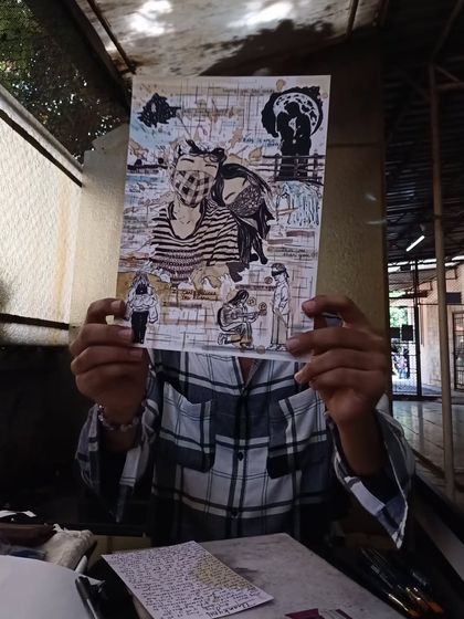 Holding up a finished memory collage. This piece tells a love story through a collection of illustrated moments, inside jokes, and meaningful symbols, all brought together with coffee art.