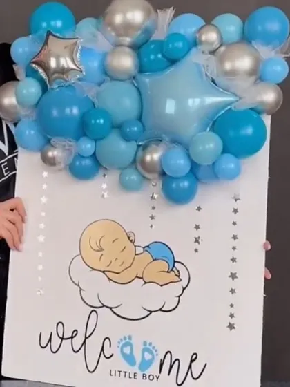 A giant welcome card for a new baby boy. The card is topped with a blue and silver balloon arrangement, making it a statement gift for the new parents.