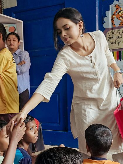 A volunteer greets children with a handshake and a smile. We strive to create a welcoming and nurturing environment in all our story sessions.