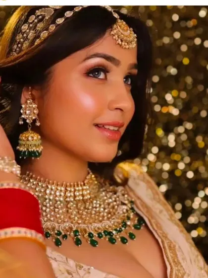 A smiling bride wearing a Pachi Kundan choker with green jhumkas. This is a lighter set, perfect for a bridesmaid or for a bride's pre-wedding event.