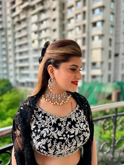 A side profile of the chic half-updo, showing the volume at the crown and the soft waves. This hairstyle is paired with a bold red lip for a classic, glamorous combination.
