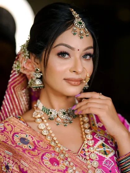 Traditional and beautiful in pink. The bride looks stunning in her patola-style saree and classic makeup.