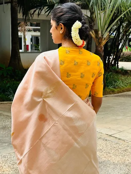 The back view of my yellow blouse, showing the simple high-neck design and my traditional hairstyle.