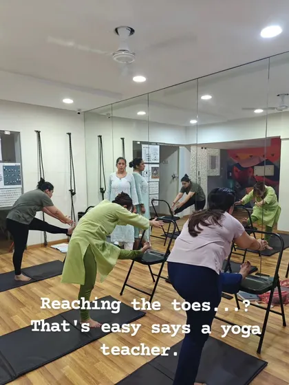 Reaching your toes is not the goal; moving with awareness is. I use props like chairs to make poses like the forward bend accessible to everyone. This ensures you can work on spinal alignment and hamstring flexibility safely, no matter your starting point.