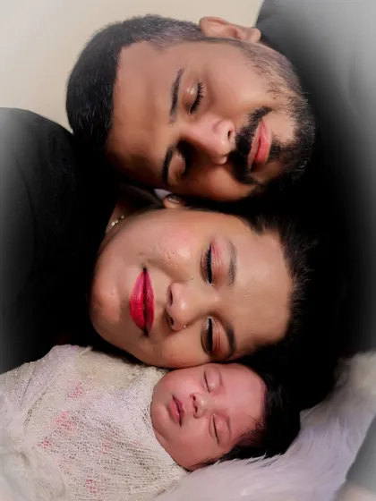 A peaceful, sleeping portrait of a new family. The soft lighting and their relaxed expressions create a serene and loving image that perfectly captures the newborn bubble.