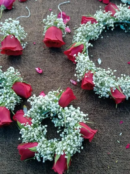 A complete set of fresh floral jewellery for the bride, including a tiara, earrings, and bracelets. This set is made with red rose buds and baby's breath.
