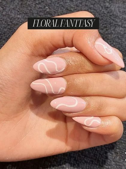 This "Floral Fantasy" design with elegant white swirls on a pink base is a beautiful example of the trendy and artistic nail styles our students learn.