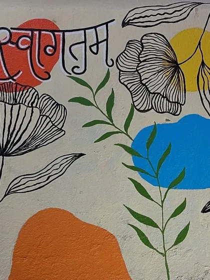 A welcoming 'Suswagatam' mural that combines traditional Marathi script with modern floral line art. This piece is designed to greet guests at an entrance.