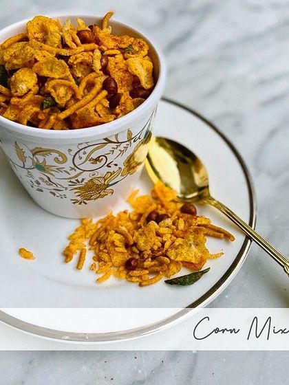 A cup full of my crunchy Corn Mixture. It's a light yet flavorful snack that combines the crispiness of cornflakes with the savory taste of traditional Indian spices.