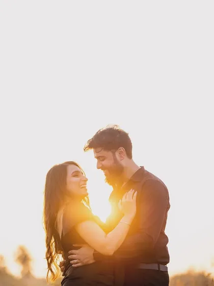 A beautiful silhouette of a couple embracing during golden hour. The warm light wraps around them, creating a halo effect that feels magical and romantic.