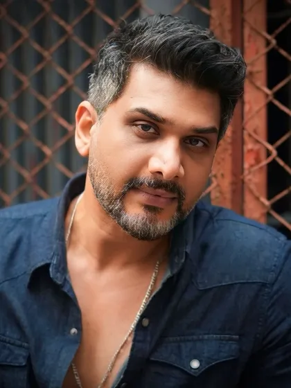 A direct-to-camera portrait of Ali Hasan, showcasing the clean lines and expert blending of his haircut and beard trim.