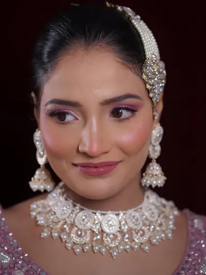 A close-up portrait showing the details of the eye makeup and the beautiful jewelry.