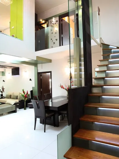This project demonstrates our expertise in space transformation. We converted a dated 3BHK flat into a modern 4BHK duplex by removing non-structural walls and adding this striking staircase with illuminated wooden treads, which serves as a functional sculpture connecting the two levels.