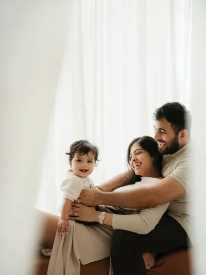 A candid moment of a family playing together, seen through a sheer curtain. This creative shot adds an artistic touch to their lifestyle family session.