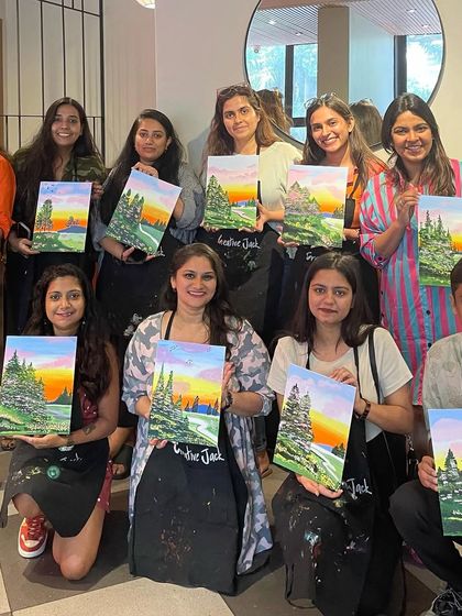 A group of participants with their serene landscape paintings. The calming process of painting is a great form of art therapy.