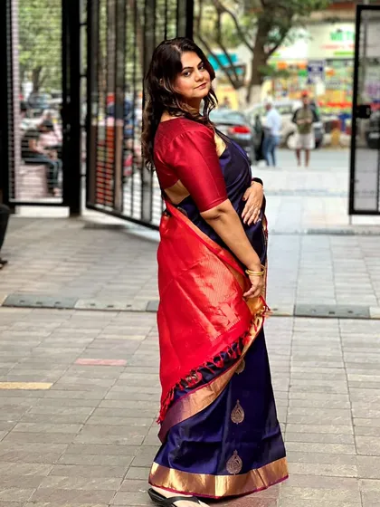 A side view showing the beautiful fall of the saree and the client's soft curls.