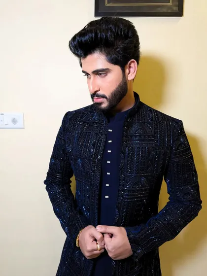 A sophisticated Indo-western look. The dark, textured bandhgala jacket is perfect for an engagement or reception, offering a modern yet classic feel.