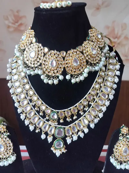 A grand, layered Polki and Kundan bridal set with a choker and a longer necklace, perfect for a royal look.