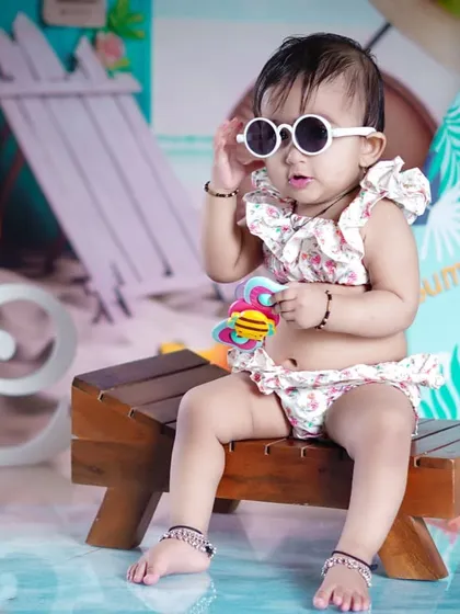 Posing like a pro with her white sunglasses, this little girl is the star of the beach.