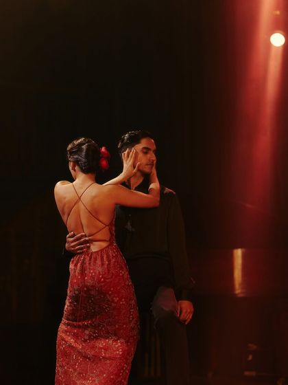 An intimate moment from the Origin & Ode shoot, focusing on the connection between the two performers. The backless dress and the simple red flower in her hair were key styling details.