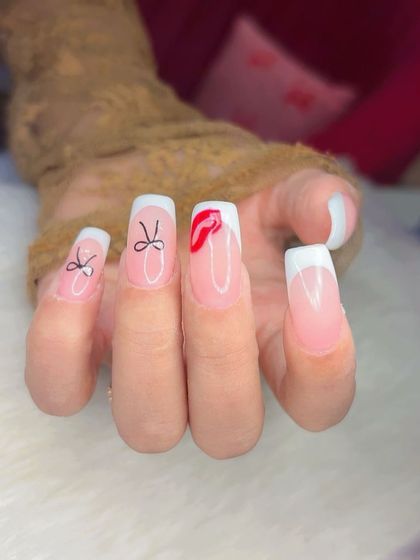 Fun and flirty French manicure with square tips, featuring hand-drawn bows and a playful red lip accent.