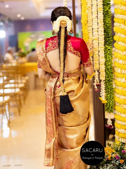 We worked with our client Anusha to create this quintessential South Indian bridal look. The back of her cherry red satin blouse features exquisite gold embroidery, designed to be seen and admired.