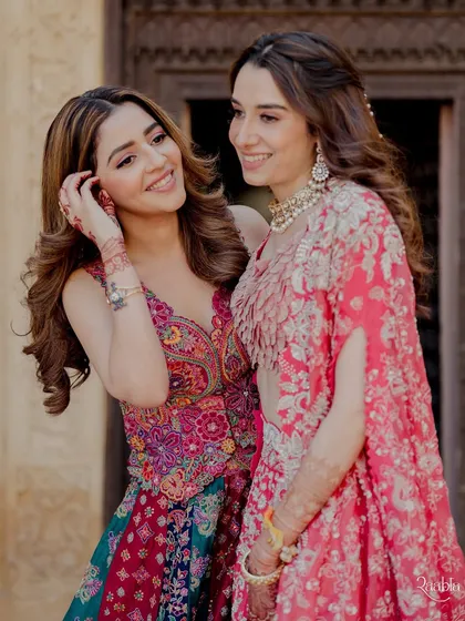 Two sisters, two stories, one celebration. Here, the bride and her sister radiate elegance in coordinated lehengas by Mrunalini Rao, showcasing how different styles can harmonize beautifully.