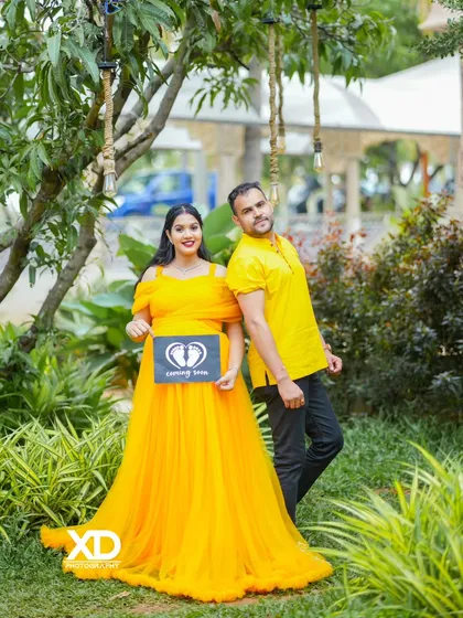 Announcing the exciting news with a cute "Coming Soon" prop. This shot combines a beautiful yellow gown with a personal touch.